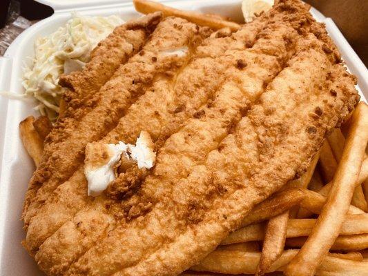 Fried haddock dinner with cole slaw and skin on fries.