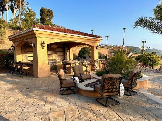 After: area now has wonderful new outdoor Kitchen Cabana, firepit/ planter & new pavers.