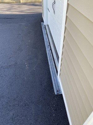 The curtain drain to guide water away from the door.