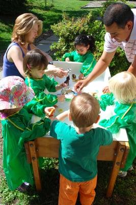 Playing with the water table. Parents and children together under the guidance of teachers at Rockville Community Nursery School