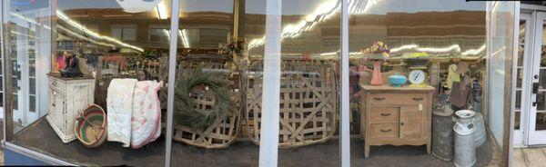 Large front window with quilts, furniture and tobacco baskets.