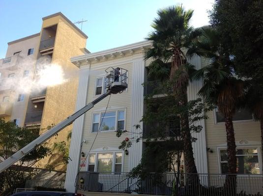 A three story building being pressure washed.  Downtown Los Angeles.