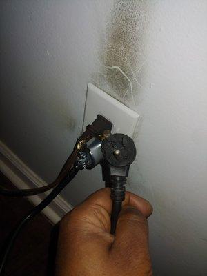 The burned up plug in my hand and the new plug is in the wall.