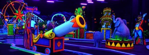 Practice your golfing skills at Rocky's Fun House Miniature Golf. An Indoor, 18 Hole, Glow-In-The-Dark Course - carnival  theme.