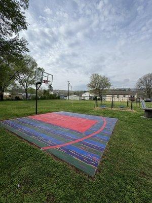 Basketball court with lines and large hoop with breakaway rim 9 foot 9 inches rim - painted by local mural artist