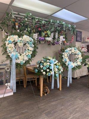 White and blue funeral pieces, open heart, casket and wreath.