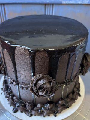 Vanilla cake w/ French buttercream between layers, topped w/ black cocoa buttercream & a chocolate salted caramel drip