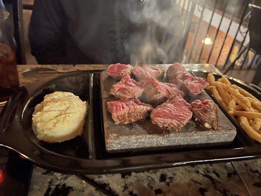 Prime rib cap cooked on a hot stone.