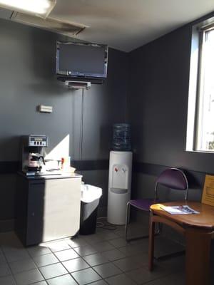 Waiting area with coffee, TV and drink machine(no prices listed). Water cooler and coffee area really dusty/dirty. Everywhere else clean.