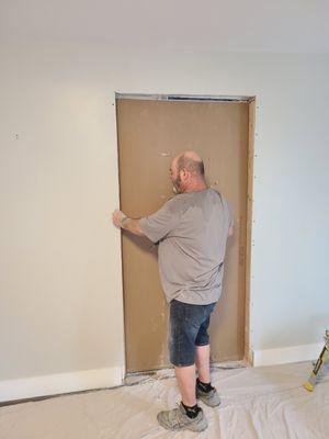 Cutting second layer Drywall on door install.