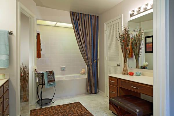 Master bath with marble floor, whirlpool bath, vanity and dressing table