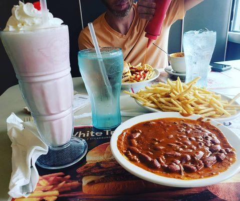 Bowl of chili with a side of fries and a half&half vanilla + strawberry milkshake