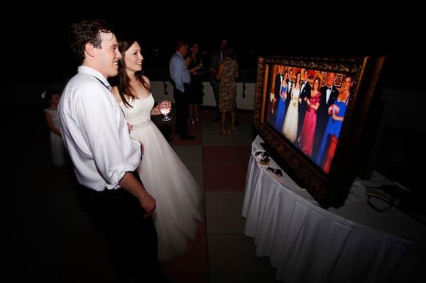 bride and groom watch instant slideshow at wedding - River Crest Country Club