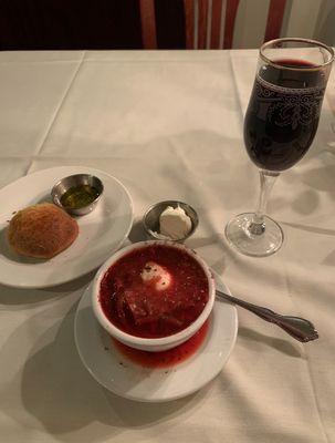 A bowl of Red Borsht with a dollop of sour cream...and a deep red wine. Look at the size of that pour !!!