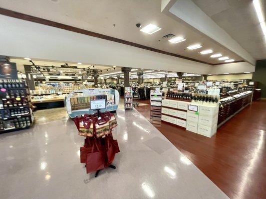 View after stepping inside, cheese cases & snacks in middle, wine to right, liquors and beer sections to left