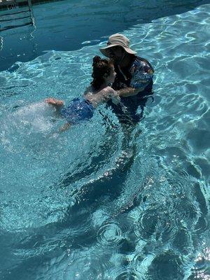 Coach Ki teaching a 3 year-old how to kick properly, as well as overcoming the fear of putting his face in the water.