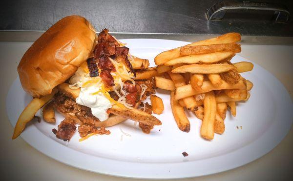 Chili Burger, a 4oz smashed burger topped with homemade chili, french fries, sour cream, shredded cheese and bacon.