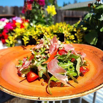 Arugula salad with shaved proscuitto, strawberries, almonds and local honey