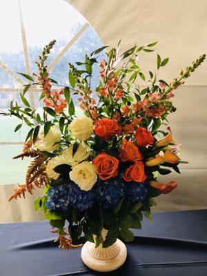 Big arrangement in blue , orange and ivory color.