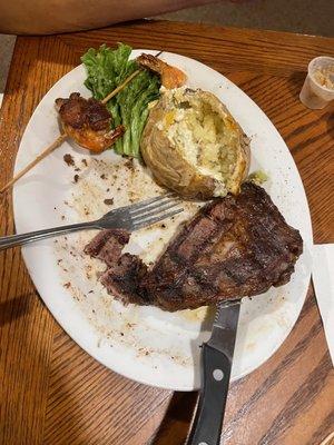 Ribeye with baked potato and shrimp skewers.