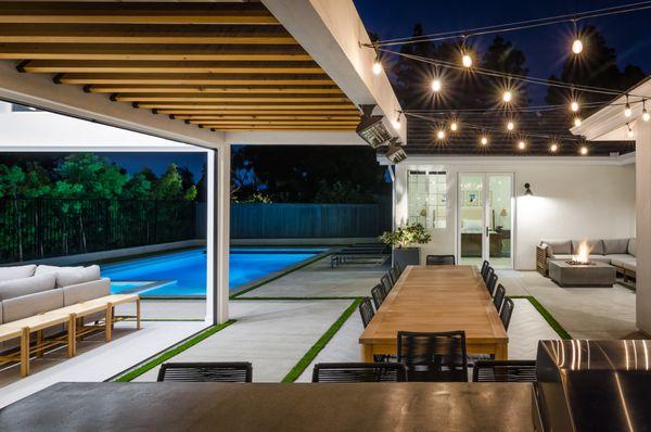 Outdoor kitchen. Fire pit. Cantilever patio attached to pool house. Turf in between gaps to separate concrete from tile.