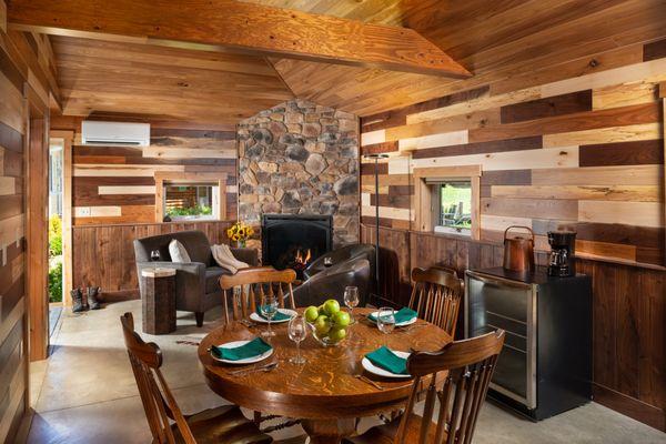 Sunrise Cottage fireplace, lounge area and dining. Wood on walls from our woodland