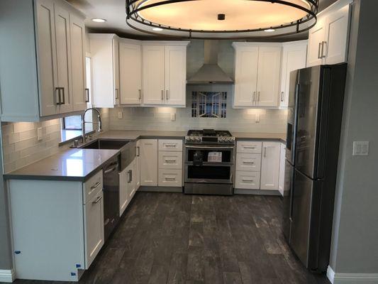 Complete kitchen remodeling, including new tile flooring, white shaker cabinets, Caesar-stone counter top and glass subway tile back splash.