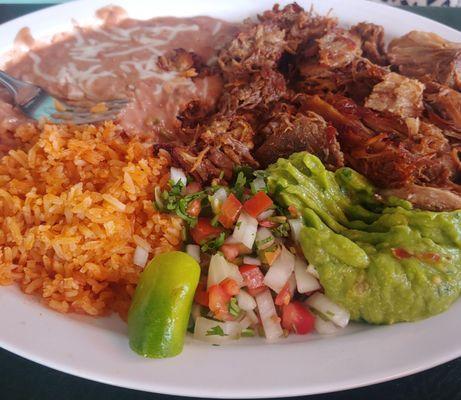 Carnita plate with rice, beans pico de gallo and guacamole.