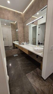 Vanity area. There's a toilet off to the right, as well as another toilet close to the showers. Lighting and Sonos are perfect!