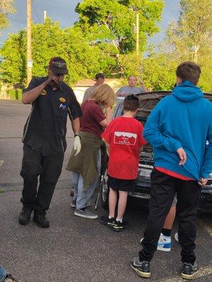 Scott explains checking and maintaining fluid levels to Scouts