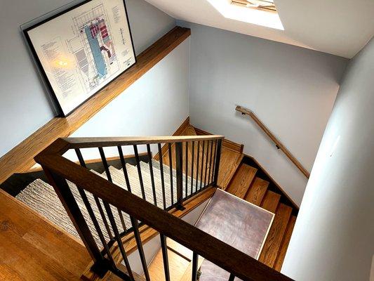 Custom railing with vertical pickets and stained red oak wood top