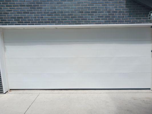 Flush type wood grain textured garage door