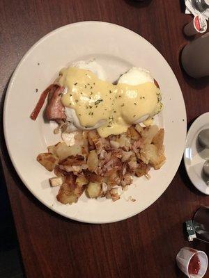 Eggs Benedict with home fries with added onion.