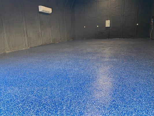 Epoxy flooring inside finished garage complete with painted insulation and electrical.