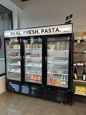 Interior - refrigerated retail items including sauces, fresh pasta, drinks, and more