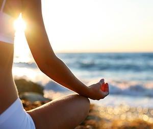 Cassie Fireman (co-founder) meditates on the beach of San Diego, CA