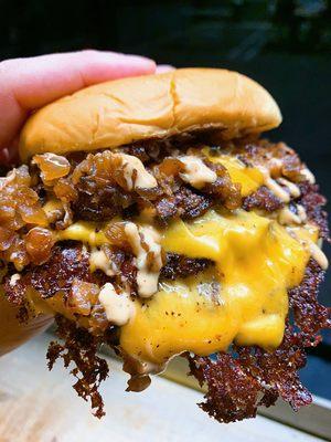 Triple cheeseburger with grilled onions and wild sauce