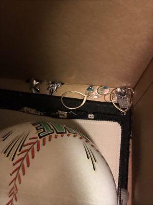 Diamond rings and earrings all loose in a box and a box with outdoor items.