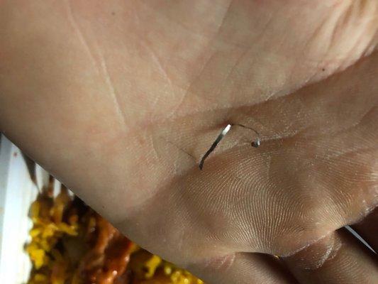 A piece of metal from a cleaning scrub brush found in lo mein