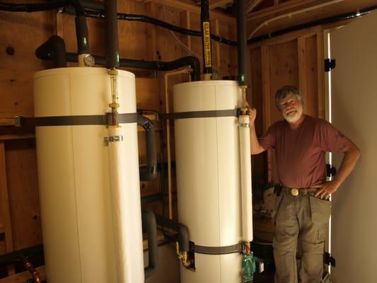 Contractor John Davis alongside two 80-gal tanks for a pool heating system in Sonoma County.