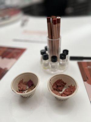 Mixing custom lipstick colors! A variety of scent flavors are in vials in the background.