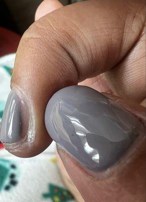 Gel manicure with uneven filing, cuticles, and polish not reaching the edges