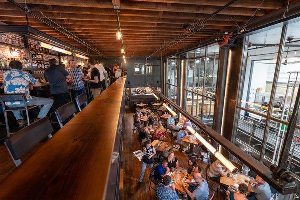 View of mezzanine bar, downstairs dining area, and distillery.