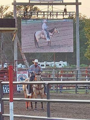 Announcer leading prayer for the safety of the riders, animals,  bull staff, and country.