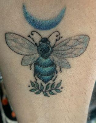 Tattoo of Australian carpenter bee with laurel branch and crescent moon.