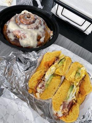 Bacon, egg and avocado on an egg everything bagel with a cinnamon bun on the side