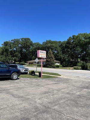 Roselle Service Center located between a strip shopping center (DQ, Dunkin' Donuts, Wing Hing Chop Suey, Doctor Dog) and Chevy dealer.