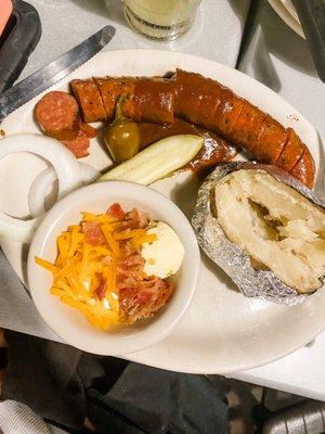 BBQ plate with sausage and loaded baked potato