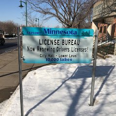 Sign at the front of the City of New Brighton City Hall indicates the License Bureau is inside the same building.