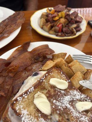 Blueberry stuffed French toast with crispy bacon and a side of corn beef hash.